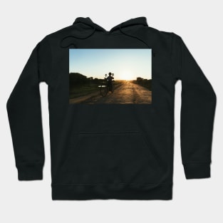 Silhouette of Boy Riding Bicycle at Sunset in Burmese Countryside Hoodie